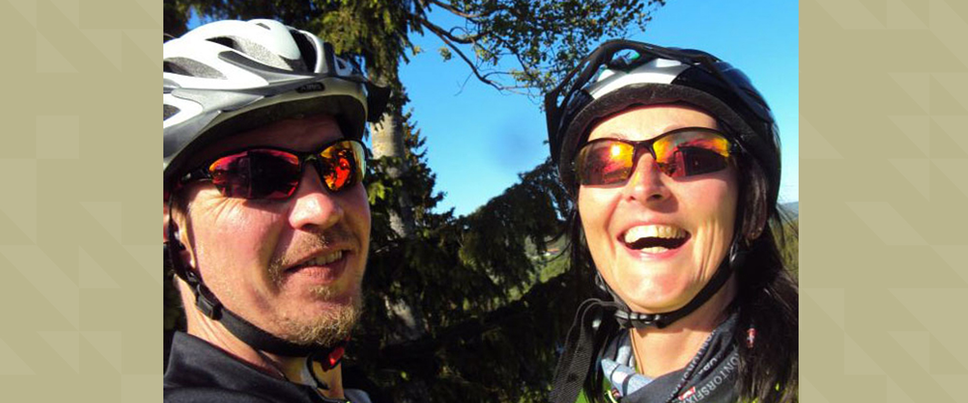 A man and a woman with helmets are smiling